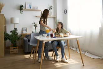 A warm scene features a lesbian couple sharing a delightful breakfast in their cozy dining room The