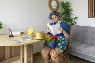 A transgender man, sitting comfortably in a modern styled room. He is deeply engaged in reading a