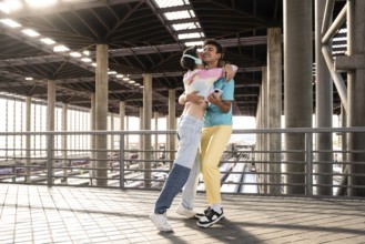 A joyful moment for a couple embracing each other at a train station. The sunlight filters through