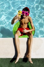 A young teenage boy relaxes on a float in a bright blue pool, wearing colorful flower-shaped