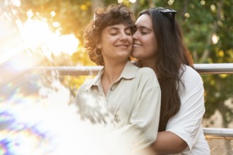 A loving lesbian couple shares a tender embrace outdoors, surrounded by vibrant nature. The