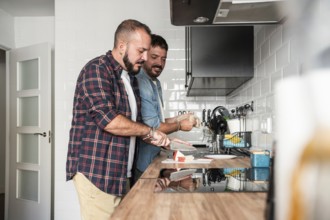 A joyful gay couple prepares a meal together in their modern kitchen, showcasing a harmonious