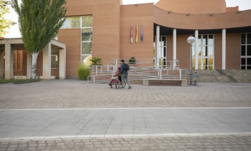 A couple traverses a college campus, highlighting accessibility and inclusion The woman, coping