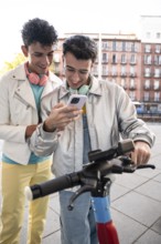 A happy gay couple, each wearing headphones, enjoys a light-hearted moment outdoors while looking
