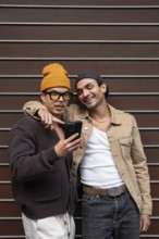 A joyful couple stands close together, sharing a moment and viewing something exciting on a