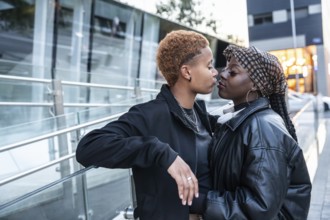 A tender moment between a loving LGBT multiethnic couple embracing in an urban setting. They