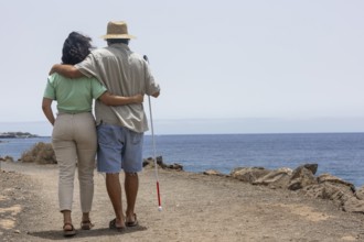 A blind man enjoying a seaside adventure with a companion. The image captures a serene moment,