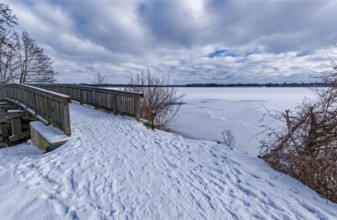 View of the Schaalsee, covered with ice and snow, on the bridge tour, a hiking trail with a wooden