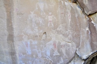 Ancient rock art, petroglyphs from the Fremont culture with human figures in shades of red and