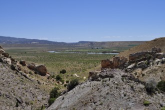 Wide valley with rocky hills and green vegetation under clear skies, Dinosaur National Monument,
