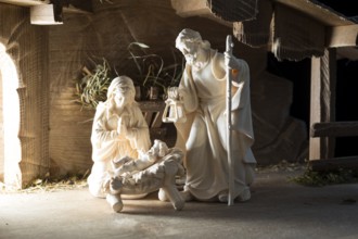 The Holy Family at the crib, wooden crib figurines represent the birth of Jesus Christ Child lying