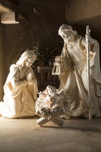 The Holy Family at the crib, wooden crib figurines represent the birth of Jesus Christ Child lying