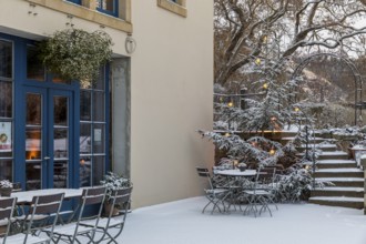 Still life of an illuminated Christmas tree, stairs and sitting area in the snow, Aust Winery,