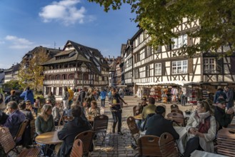 Busy cafe on Place Benjamin Zix and the Maison des Tanneurs timber-frame house in Petite France,