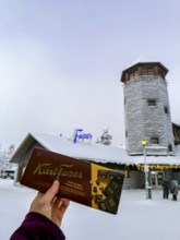 Karl Fazer hand holding chocolate in front of a Fazer shop, typical Finnish chocolate, Ranua,