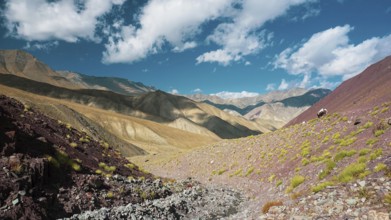 Mountain panorama, diverse mountain landscape with barren soil and colorful colors under cloudy
