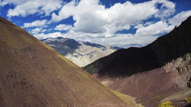 View of a shady, colorful mountain landscape with dramatic sky and clouds, trekking in Ladakh, Stok