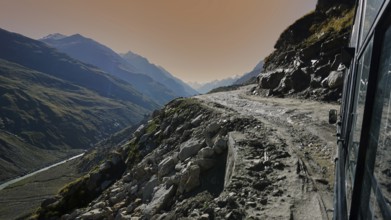 Drive along a mountain road on the Manali-Leh Highway at sunset with dramatic views of the mountain