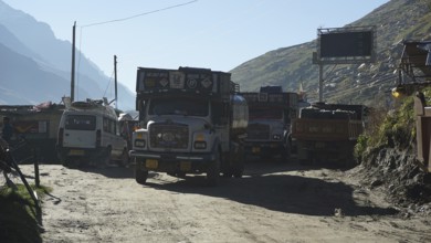 Several trucks on a mountain road in a small village in sunny weather on the Manali-Leh Highway,