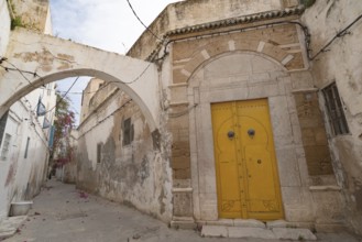 An ornate yellow door of typical Tunisian architecture in the colourful alleyways of the Medina in