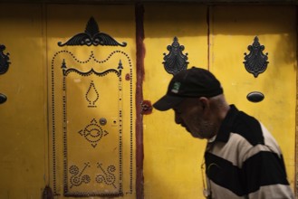 Tunis, Tunisia 7th May, 2024 Beautiful decorated traditional yellow door in the souk of Tunis