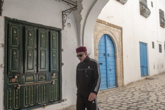 Tunis, Tunisia 4th May, 2024 A Tunisian man wearing a red chechia hat in the beautiful narrow