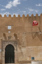 The Tunisian national flag flying from inside the ancient city walls of the medieval medina of Sfax