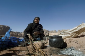Petra, Jordan. December 13th 2012 Jordanian Bedouin woman brews tea on an open fire, Petra, Jordan