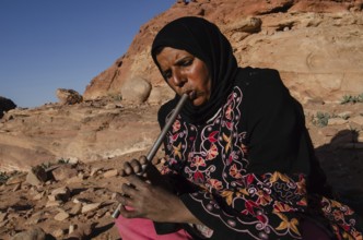 Petra, Jordan. December 13th 2012 A Jordanian Bedouin woman plays music on a pipe, Petra, Jordan
