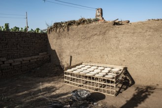 Freshly made dough to make traditional bread drying in the sun outside a typical mud brick house in
