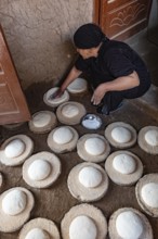 Luxor, Egypt. 13th December 2020 An Egyptian woman preparing dough to make bread in a Nile side