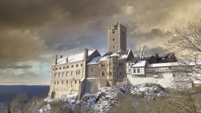 Wartburg in Eisenach under a dramatically lit sky in a wintry atmosphere, hiking on the Rennsteig,