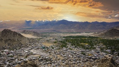 Extensive panoramic view of Leh with snowy mountains in the background under a colorful sky, Leh,