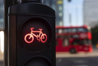 A red cycle lane traffic stop signal at a junction in a busy London city street with a double