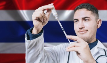 Doctor holding syringe on Thailand flag background. Medical professional holding syringe with Thai