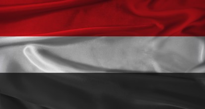Flag of Yemen with fabric textured background. Close up of National flag of Yemen with realistic