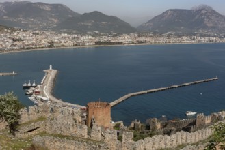 Beautiful landscape view of Alanya Harbour and the Red Tower with the Taurus Mountains and