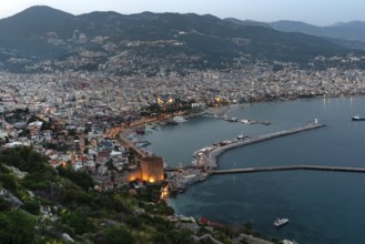 Beautiful evening view of Alanya Harbour and the Red Tower with the Taurus Mountains and
