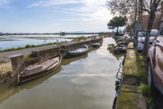 Traditional boats moored along a narrow canal in el palmar fishing village, reflecting the sky and