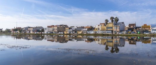 Traditional houses of el palmar fishing village reflecting perfectly on the calm water surface of