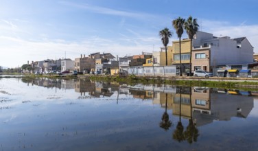 El palmar fishing village and palm trees mirrored in calm flooded rice paddies of albufera natural