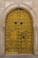 Detailed yellow ornate design of a typical door in the Medina of Tunis, a UNESCO designated quarter