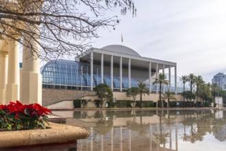Palau de la musica, a modern concert hall featuring a glass facade and white columns, reflecting on