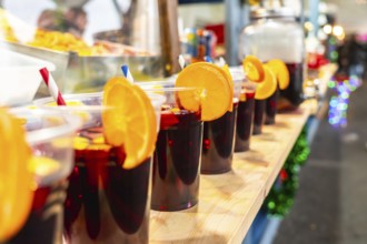 Refreshing sangria beverages served in plastic cups with vibrant orange garnishes and red and blue