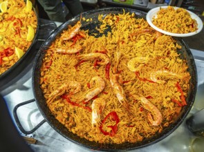 Large paella pan presenting fideua, a traditional spanish noodle dish from valencia, prepared with