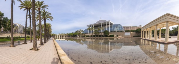 Palau de la musica concert hall architecture reflecting in a calm water pond, surrounded by palm