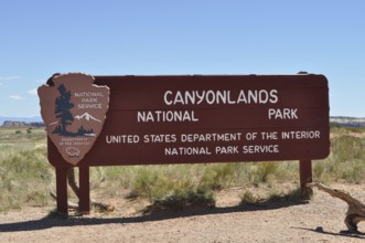 Sign for Canyonlands National Park in a desert landscape under clear skies, Canyonlands National