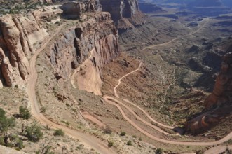 Long gravel road winds through a dramatic desert landscape, Canyonlands National Park, Island in
