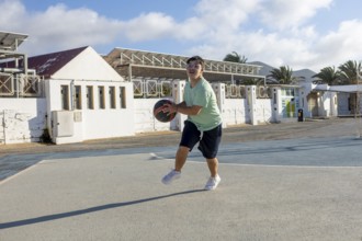 A Down syndrome teenager actively participates in a lively basketball game, This heartwarming scene
