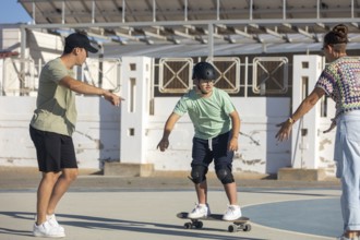 Down syndrome teenager skateboarding with encouragement and support from family members Empowering